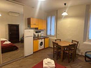 a kitchen and dining room with a table and a refrigerator at Suite Cerchio 3 - City Center in Ravenna