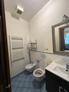 a bathroom with a toilet and a sink and a mirror at Suite Cerchio 3 - City Center in Ravenna