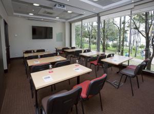 a classroom with tables and chairs and windows at Cité Hotel in Bogotá