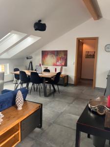 a living room with a table and chairs at Nussböckgut - Winzerhof mit gratis Parkplatz in Linz +22 photos