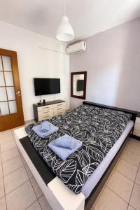 a bedroom with a large bed with blue pillows on it at Sampa Villa in Asprovalta