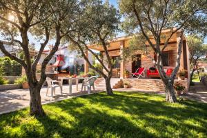 a backyard with a table and chairs and trees at Sampa Villa in Asprovalta