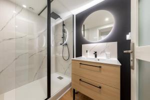 a bathroom with a shower and a sink and a mirror at Air Nomad • Vancouver in Valenciennes
