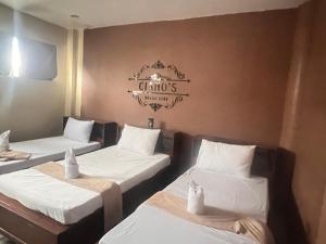 a room with three beds and a sign on the wall at Ciano's Hostel Cebu in Cebu City