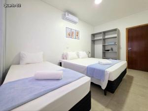 two beds in a hotel room with two beds at 3 Frontiers Landmark House in Foz do Iguaçu
