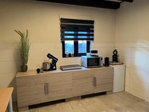 a kitchen with a counter with a microwave and a window at Relaxed Guesthouse in Heibloem