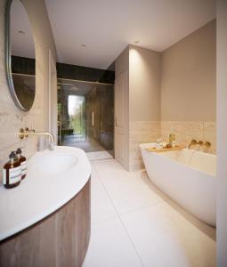 a bathroom with two sinks and a tub and a mirror at Aysgarth Falls Hotel & Restaurant in Aysgarth