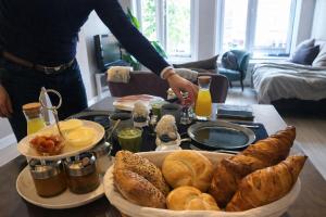 a tray of bread and pastries on a table at Bed and Breakfast The Rose in Haarlem