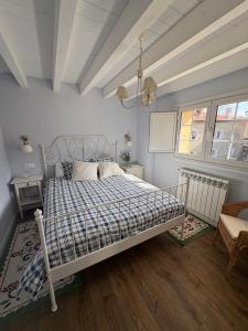 a bedroom with a bed with a blue and white comforter at La Casa de Nueva in Nueva de Llanes