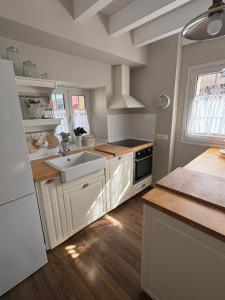a kitchen with white cabinets and a sink at La Casa de Nueva in Nueva de Llanes +12 photos