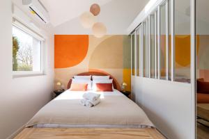 a bedroom with a bed with orange and yellow walls at Air Nomad • Séville in Valenciennes +13 photos