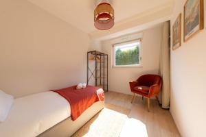 a bedroom with a bed and a chair and a window at Air Nomad • Séville in Valenciennes
