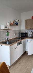 a kitchen with white cabinets and a sink at Ferienwohnung Tschitschmann in Naumburg