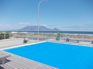a swimming pool with a view of the ocean at Blouberg Studio Wow in Bloubergstrand