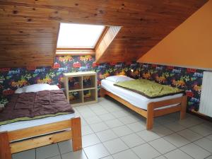 two beds in a room with wooden ceilings at Gite 2 de Renuamont in Sainte-Ode
