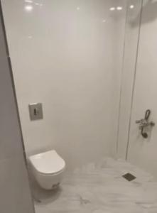 a bathroom with a white toilet and a shower at موتيل رويا in Erbil