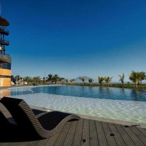 a swimming pool with two chairs next to a wooden deck at Luxury Villa by Andres in San Juan