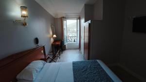 a bedroom with a bed and a view of a balcony at Hotel Richmond Gare du Nord in Paris +51 photos