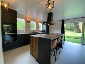 a kitchen with a island with bar stools in it at Bandrew in Stoumont