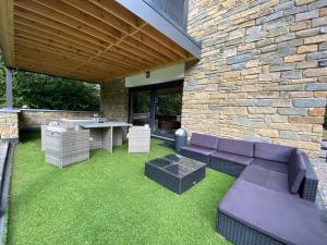 a patio with a purple couch and a table and chairs at Bandrew in Stoumont
