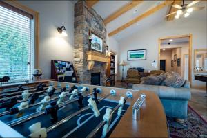 a living room with a pool table in front of a fireplace at Lakeside Funscape LS33 Ski & Snowboard Hot Tub in Huntsville