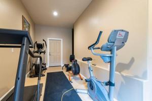 a gym with a blue treadmill and exercise bikes at Lakeside Funscape LS33 Ski & Snowboard Hot Tub in Huntsville