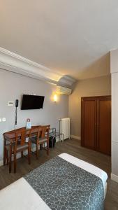a hotel room with a bed and a table and a television at Hotel Richmond Gare du Nord in Paris