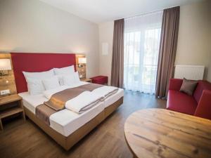 a bedroom with a large bed and a red headboard at Hotel-Gasthof Neue Post in Leutershausen