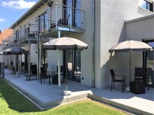 a patio with tables and chairs and umbrellas at Hotel-Gasthof Neue Post in Leutershausen