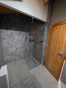 a bathroom with a shower with a glass door at Secluded Log Cabin escape in High Wycombe +7 photos