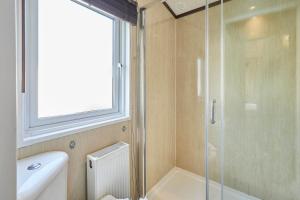 a bathroom with a shower and a toilet and a sink at Lakeside Gem with Hot Tub in York +22 photos