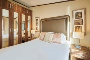 a bedroom with a large white bed and two lamps at Lakeside Gem with Hot Tub in York