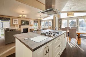 a kitchen and living room with a stove top at Lakeside Gem with Hot Tub in York