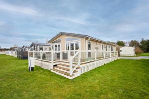 a large house with a large deck on a lawn at Lakeside Gem with Hot Tub in York