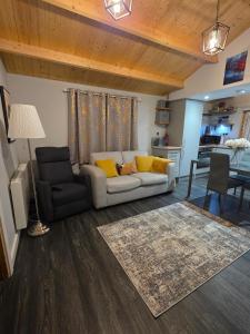 a living room with a white couch and yellow pillows at Secluded Log Cabin escape in High Wycombe