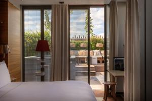 a bedroom with a bed and a view of a balcony at Brach Paris - Evok Collection in Paris