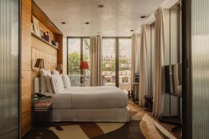 a bedroom with a white bed and a large window at Brach Paris - Evok Collection in Paris +44 photos
