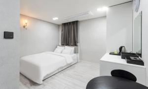 a white room with a white bed and a window at Regen Hotel in Seoul