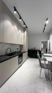a kitchen with white cabinets and a table and a chair at Квартира подобово класу "ЛЮКС" in Khmelnytskyi