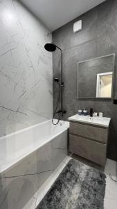 a bathroom with a tub and a sink and a mirror at Квартира подобово класу "ЛЮКС" in Khmelnytskyi +8 photos