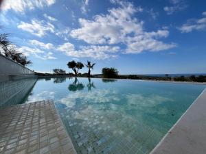 a swimming pool with a blue sky and clouds at Villa Lippia in Misraħ Miel