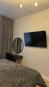 a bedroom with a bed and a mirror and a tv at Квартира подобово класу "ЛЮКС" in Khmelnytskyi