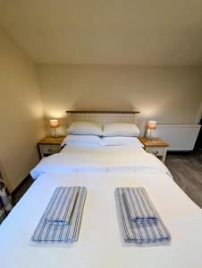 a bedroom with a large white bed with two baskets on it at The Garden Lodge in Llynclys
