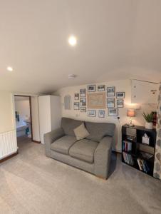 a living room with a couch and pictures on the wall at The Garden Lodge in Llynclys