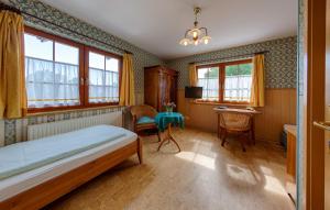 a bedroom with a bed and a table and windows at Hotel & Restaurant Landhaus Hönow in Hönow +8 photos