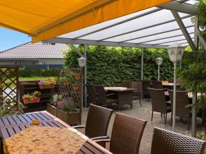 a patio with tables and chairs under a canopy at Hotel & Restaurant Landhaus Hönow in Hönow