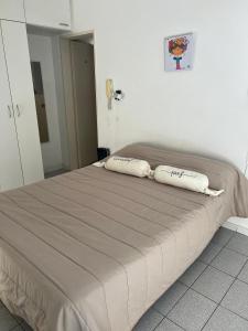 a bed with two pillows on it in a bedroom at Monoambiente Supercéntrico! San Martín 436 in Tandil