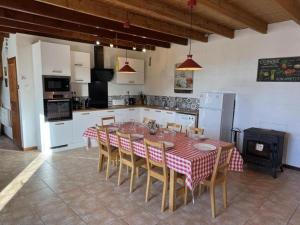a kitchen with a table and chairs in a room at Les volets bleus in Saint-Saviol