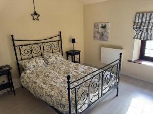 a bedroom with a bed with a black frame at Les volets bleus in Saint-Saviol
