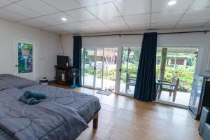 a bedroom with a large bed and a sliding glass door at อินทนนท์ขุนเล่าลือ in Ban Na Yang